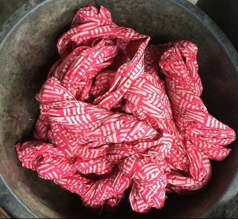 Red and white patterned fabric in a metal bowl
